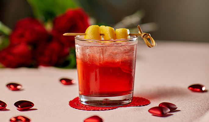 Valentine's Day red cocktail with a spiraled orange peel garnish